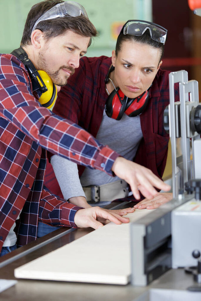 man and lady using industrial circular saw - Photo, Image