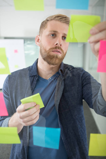 creative businessman looking at sticky notes - 写真・画像