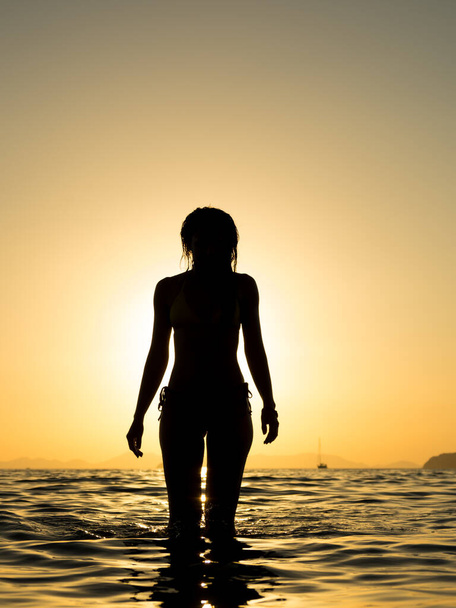 Žena v plavkách pózuje na pláži při západu slunce - Fotografie, Obrázek