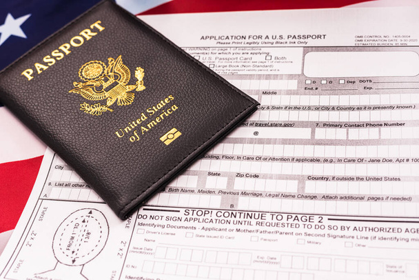 新しいアメリカのパスポート、愛国的な旗の背景を取得するための申請書. - 写真・画像
