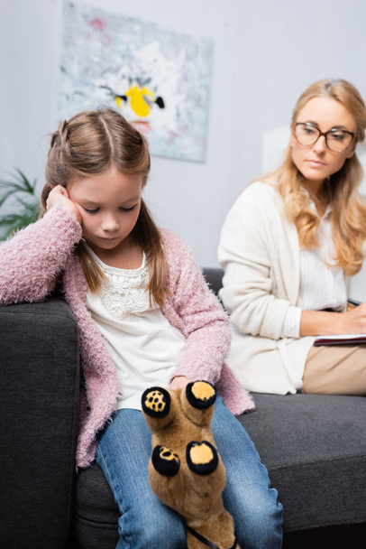 upset little girl patient with toy visiting psychologist - Photo, Image