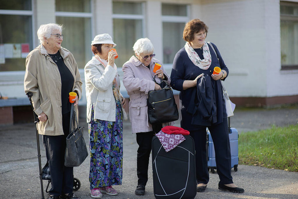 Skupina pozitivních seniorů starší ženy cestovatelé pít kávu a komunikovat před odjezdem na výlet - Fotografie, Obrázek