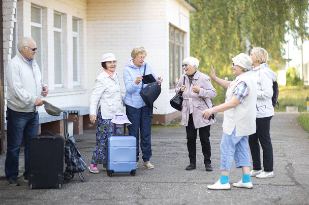 Un grupo de personas mayores positivas viajeros que esperan el tren antes de salir de viaje - Foto, imagen