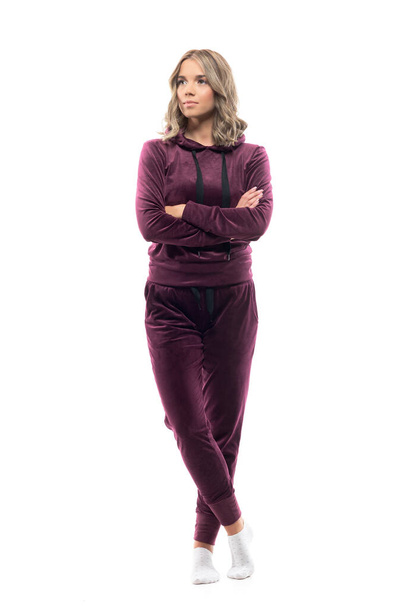 Confident beautiful young cute woman with crossed hands in tracksuit looking away interested. Full body isolated on white background. - Photo, Image
