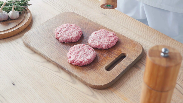 Vista recortada del chef condimento empanadas de carne picada en la tabla de cortar - Metraje, vídeo
