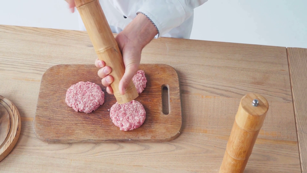 Gehakt uitzicht op chef-kok met molen kruiden gehakt pasteitjes op snijplank - Video