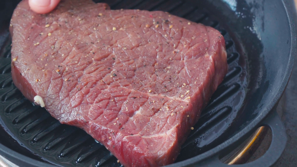Vista cortada do chef colocando bife de carne temperada na panela de grelha - Filmagem, Vídeo