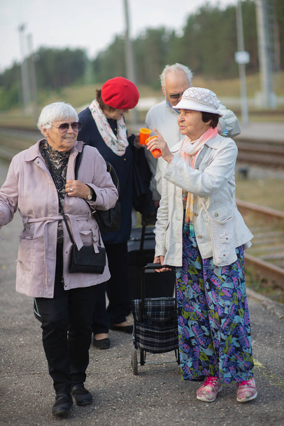 Personas mayores positivas que esperan tren antes de viajar durante una pandemia - Foto, Imagen