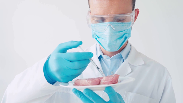 Siringa di laboratorio per iniezione in pezzo di maiale isolato su bianco - Filmati, video