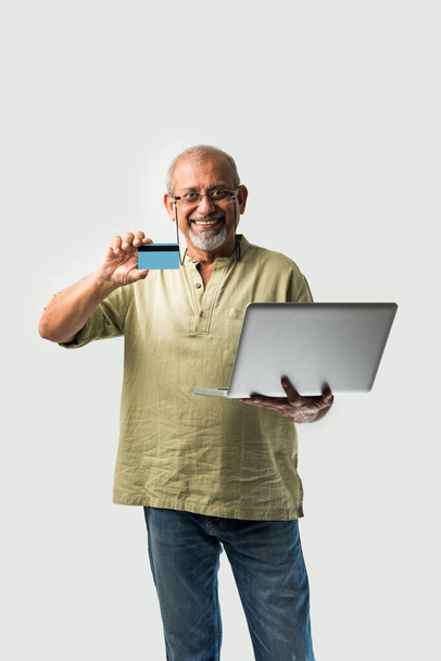 Senior IAsian Indian Adult Holding Laptop con carta di credito, shopping online o e-commerce concetto - Foto, immagini