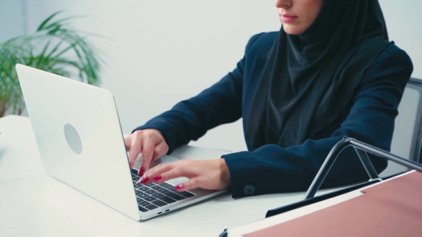 Ausgeschnittene Ansicht muslimischer Geschäftsfrau mit Laptop im Büro  - Filmmaterial, Video