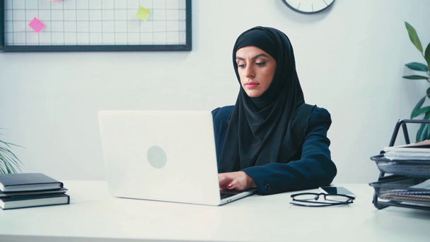 Femme d'affaires musulmane tapant sur ordinateur portable dans le bureau  - Séquence, vidéo