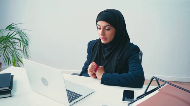 Muslimská podnikatelka s video chat na notebooku při práci v kanceláři  - Záběry, video
