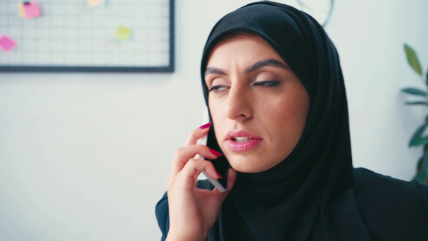Μουσουλμάνα επιχειρηματίας που μιλάει στο smartphone στο γραφείο  - Πλάνα, βίντεο