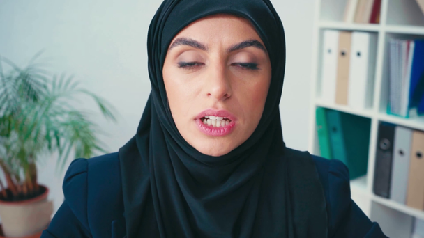 Sorridente donna d'affari musulmana che parla alla telecamera in ufficio  - Filmati, video