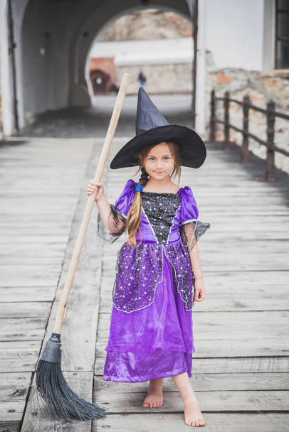 jeune sorcière se tient avec un balai dans le château - Photo, image