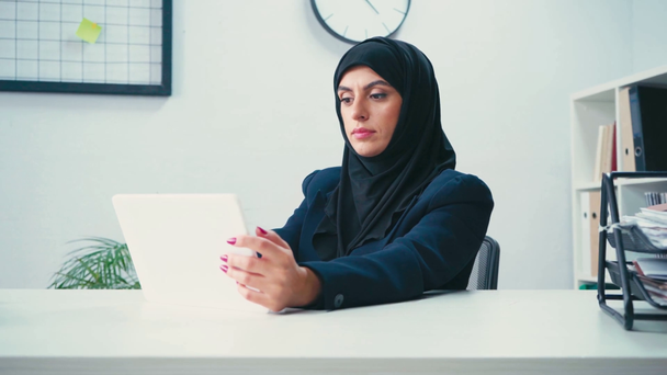 Μουσουλμάνα επιχειρηματίας που χρησιμοποιεί ψηφιακή ταμπλέτα στο γραφείο  - Πλάνα, βίντεο