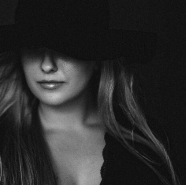 Beautiful blonde woman wearing a hat, artistic film portrait in black and white for fashion campaign and beauty brand - Foto, Imagem