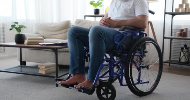 Handicapped senior man sitting on wheelchair at home - Footage, Video