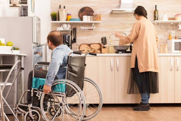 Homem com deficiência abre geladeira - Foto, Imagem