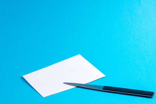 Mavi üzerinde mektup açacağı olan boş bir zarf - Fotoğraf, Görsel