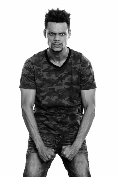 Studio shot of young African man standing while looking angry - Fotó, kép