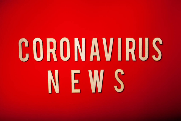 Coronavirus News sözcüğü kırmızı arkaplan koronası virüsü covid-19 hakkında ahşap harf - Fotoğraf, Görsel