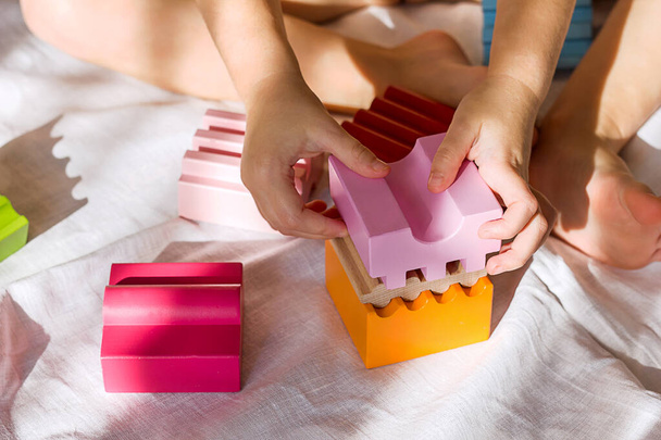 criança pequena brinca com o desenvolvimento de brinquedos de madeira, close-up - Foto, Imagem