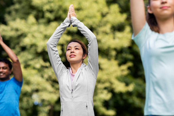 grupa osób uprawiających jogę w letnim parku - Zdjęcie, obraz