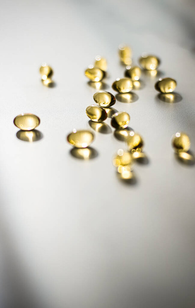 Vitamin D und goldene Omega-3-Pillen für gesunde Ernährung, Fischöl Nahrungsergänzungspille Kapseln, Gesundheitswesen und Medizin als Hintergrund für die Apotheke - Foto, Bild