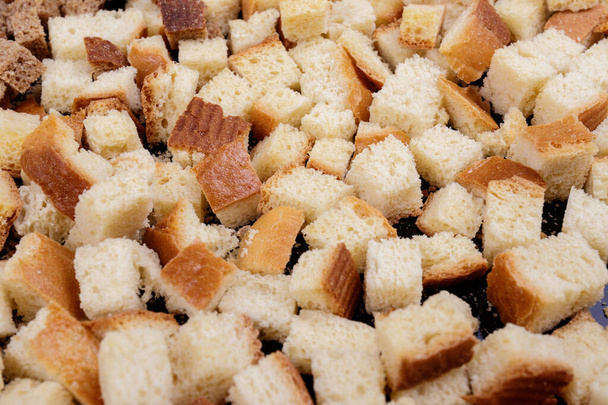 Trozos de pan blanco asado sobre un fondo oscuro. Primer plano de deliciosos croutons. - Foto, Imagen