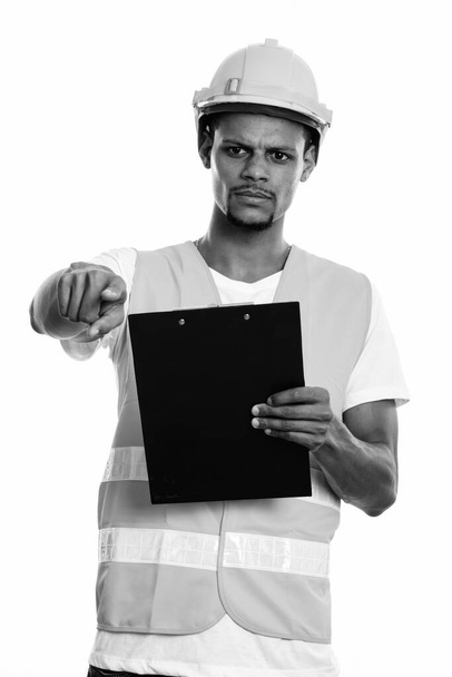 Θυμωμένος Αφρικανός εργάτης οικοδομών κρατώντας πρόχειρο ενώ δείχνει το δάχτυλο - Φωτογραφία, εικόνα