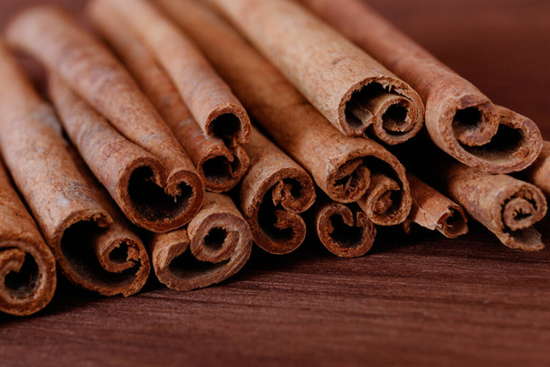 Cinnamon sticks closeup on dark wood background. - Photo, Image