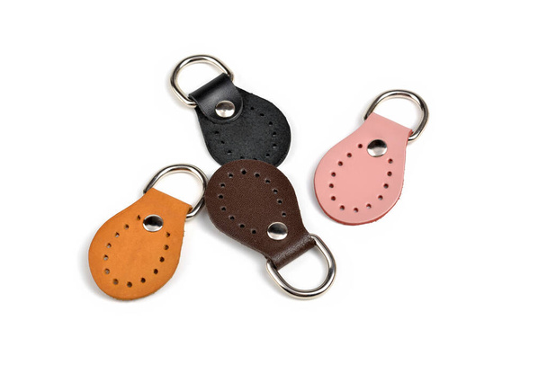 Blank orange pink black brown round color leather key chain collection on isolated white background with clipping path. Pile set of metallic souvenir. - Photo, Image