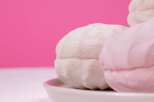 Sabroso zephyr dulce en un plato y fondo rosa pastel. - Foto, Imagen
