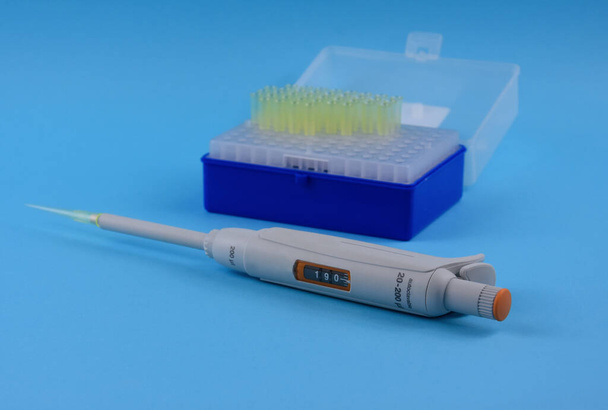 Micro pipette isolated on a blue background stock images. Laboratory accessories images. Laboratory equipment stock photo. Micropipette isolated on a blue background - Photo, Image
