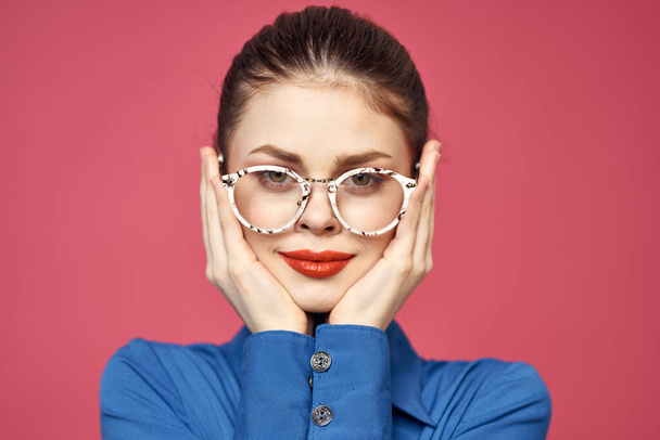 Portrait of a woman in glasses and in a blue shirt red lips pink background model - Zdjęcie, obraz