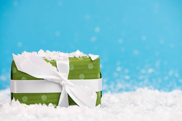 Oppervlakte niveau van miniatuur cadeau met kunstmatige sneeuw op wazig achtergrond, nieuwjaar concept - Foto, afbeelding