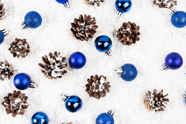 Pose plate avec des cônes de pin et des boules de Noël sur fond texturé blanc - Photo, image