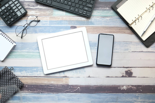 digitální tablet, chytrý telefon a stacionární na dřevěném pozadí  - Fotografie, Obrázek