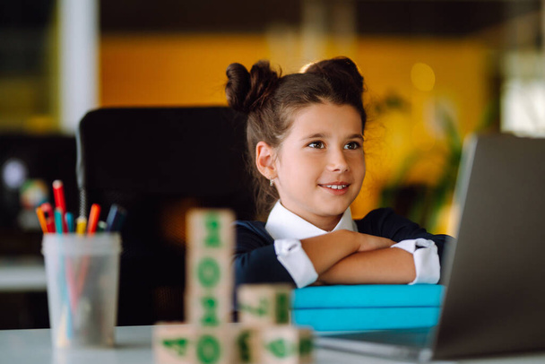 Stylish school girl sitting at the table with books. Self-isolation, online education concept, home schooler. Covid-2019. - Фото, изображение