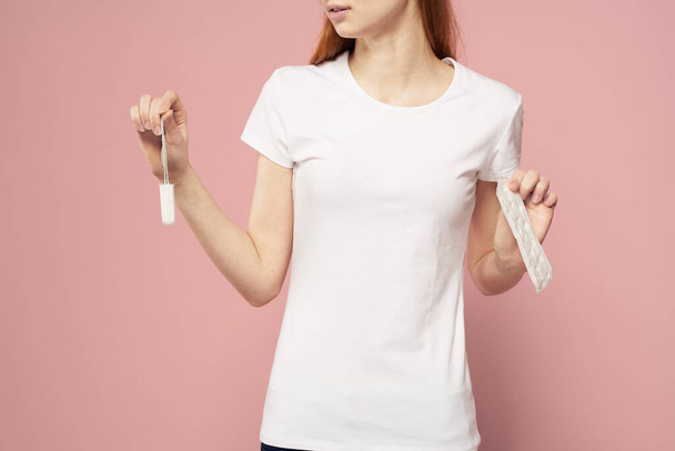 Ragazza con un pad e assorbenti in mano rosa sfondo mestruazioni giorni critici igiene - Foto, immagini