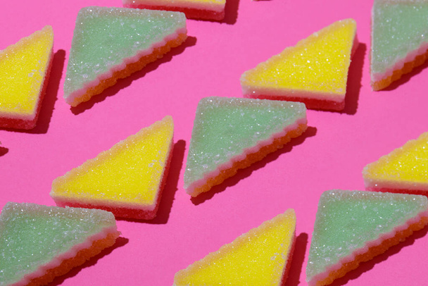 Líneas de caramelo de gelatina triangular sobre fondo rosa. - Foto, imagen