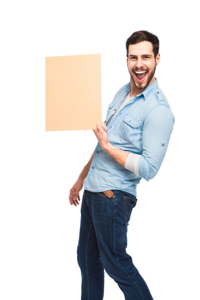 Young handsome man casual dressed with blank wooden panel - Photo, Image