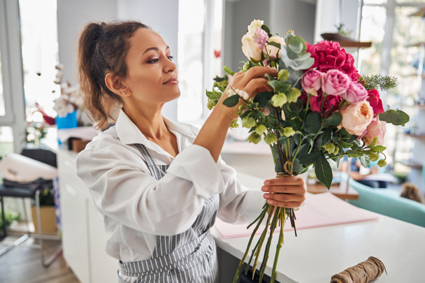 Fleuriste créative admirant un bouquet qu'elle a fait - Photo, image