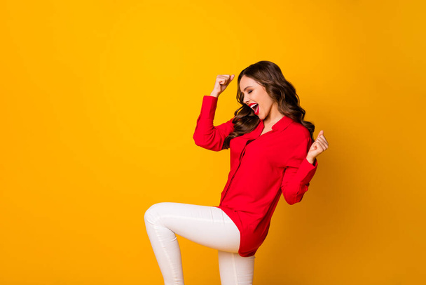 Çılgın dalgalı kadının profil fotoğrafı heyecan verici iş kurma yarışması için sevinç dolu yumruklar kaldırın kırmızı ofis gömleği giyin beyaz pantolon giyin parlak sarı arka plan - Fotoğraf, Görsel