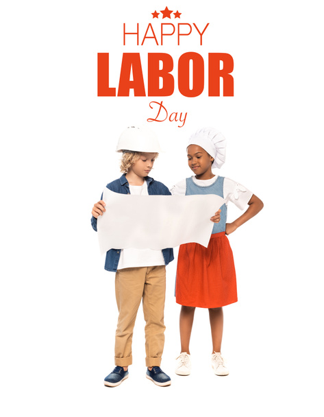 curly boy in safety helmet and american kid in chef hat looking at blueprint near happy labor day lettering on white  - Φωτογραφία, εικόνα