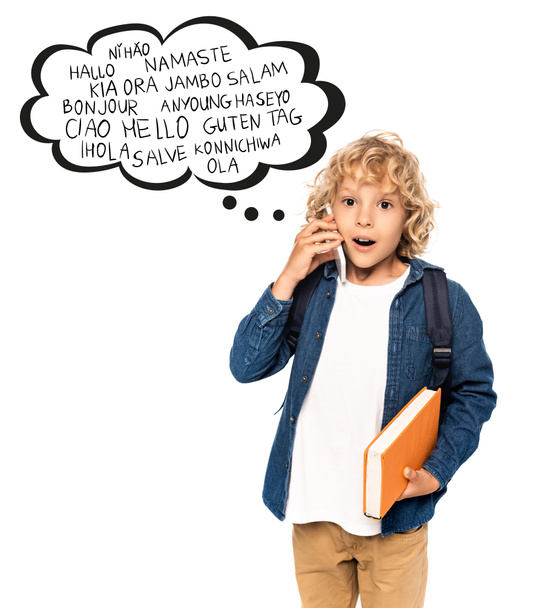 Şok olmuş ve sarışın okul çocuğu elinde kitapla konuşma balonunun yanında beyaz üzerine selamlama sözcükleri ile akıllı telefondan konuşuyor.  - Fotoğraf, Görsel