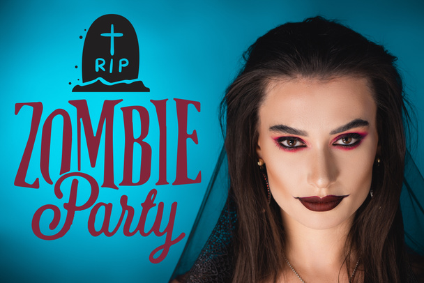 woman with black makeup and veil looking at camera near zombie party lettering on blue - Photo, Image