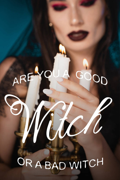 mujer pálida con maquillaje tocando velas ardientes cerca eres una bruja buena o mala escritura bruja en azul - Foto, imagen